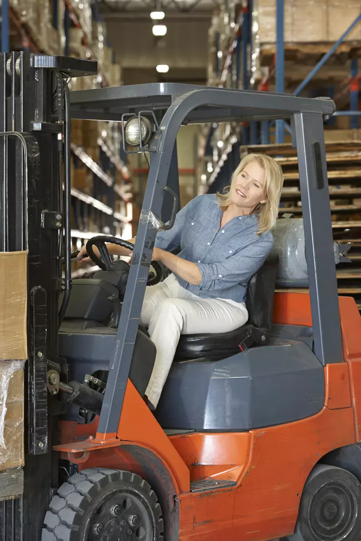 woman-driving-fork-lift-truck-in-warehouse-2023-11-27-05-33-38-utc